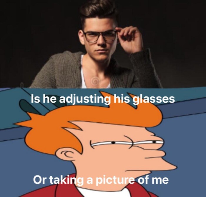 Is he adjusting his glasses Or taking a picture of me